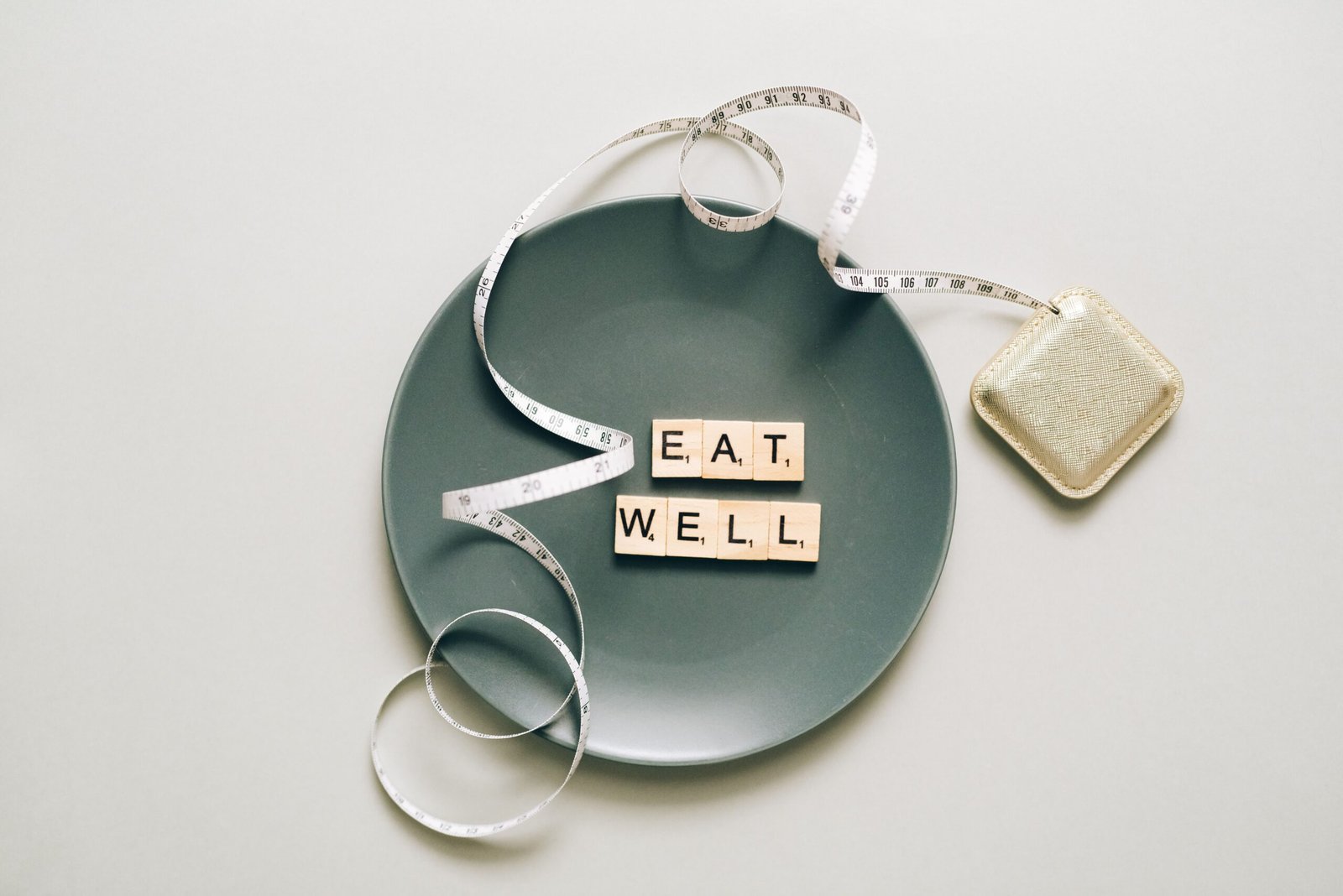 Eat Well tiles on a plate with a tape measure
