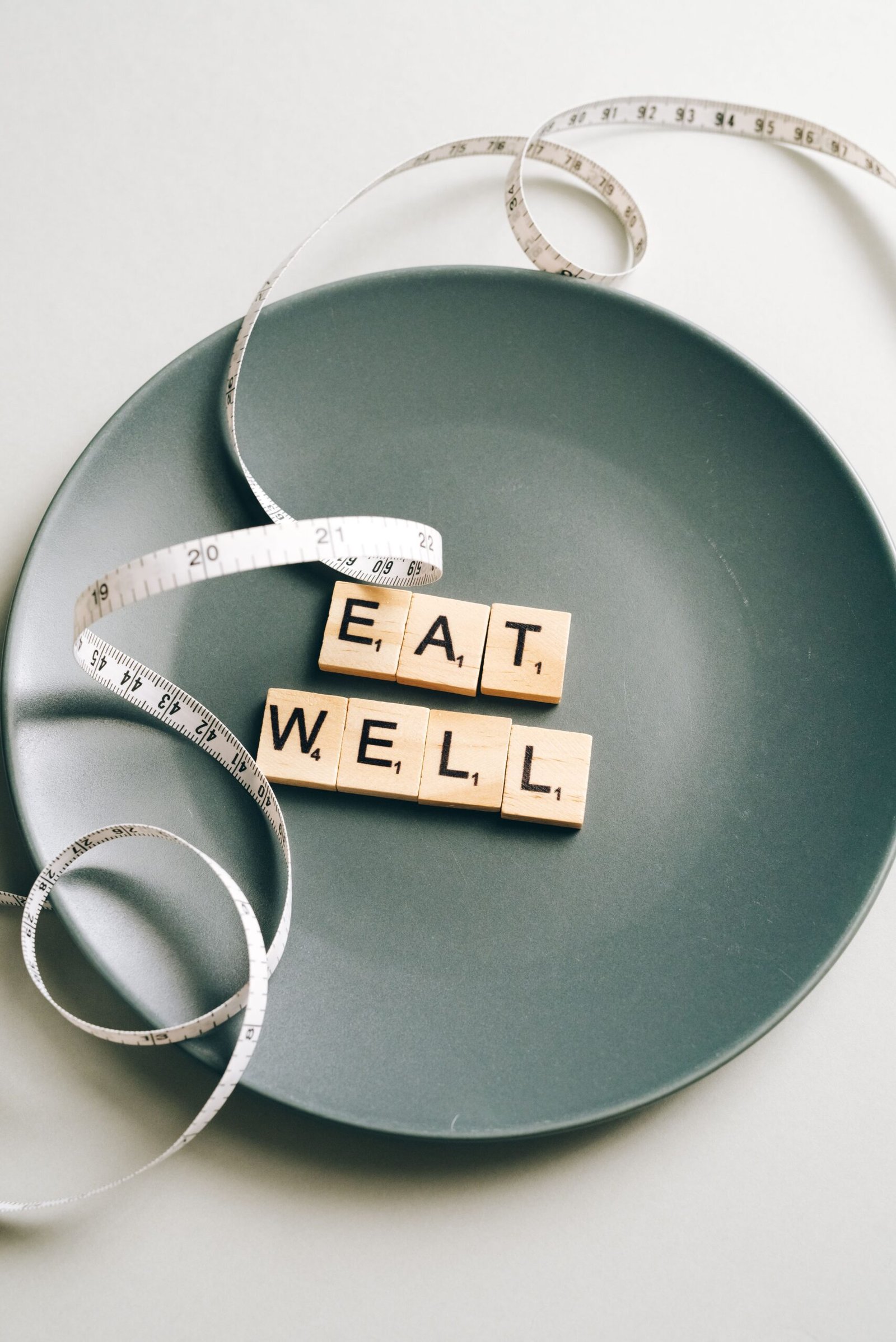 Eat Well letter tiles on a plate with a measuring tape
