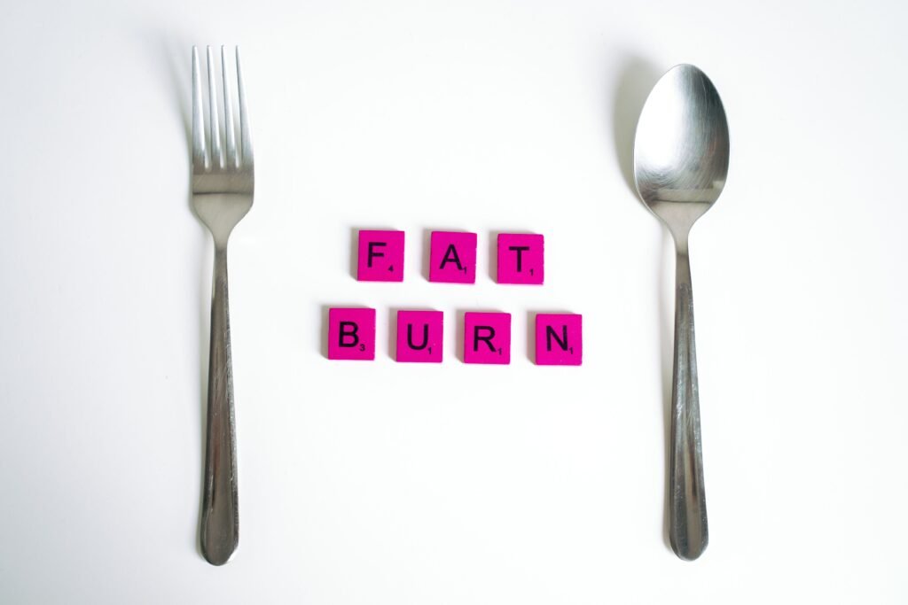 Fat Burn scrabble tiles between a fork and spoon