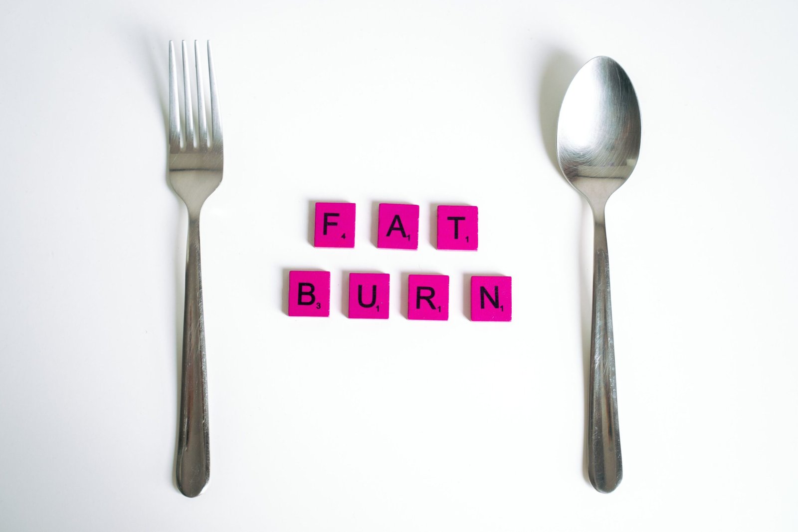 Fat Burn scrabble tiles between a fork and spoon